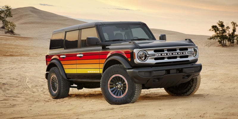 A Ford Bronco with retro red and yellow stripes in a desert