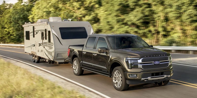 A black Ford F-150 towing Trailor