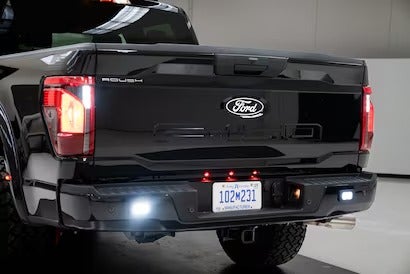 The rear view of a black Ford F-150 with a ROUSH bumper