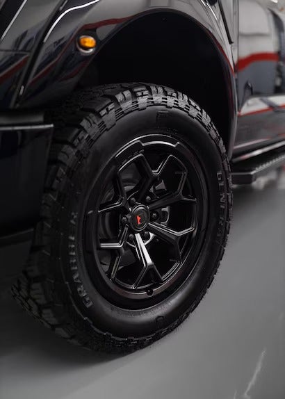 A detailed shot of the truck's black multi-spoke wheel and tire