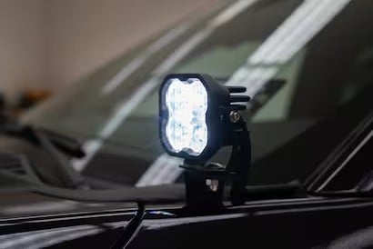 A detailed shot of a mounted LED pod light on a truck hood