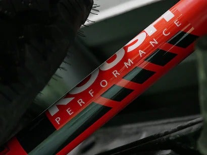 A close-up of a red performance shock absorber with a logo