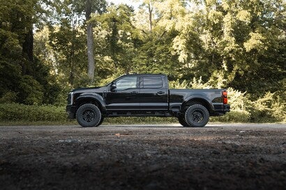 A wide shot of a black ROUSH Super Duty truck parked outdoors